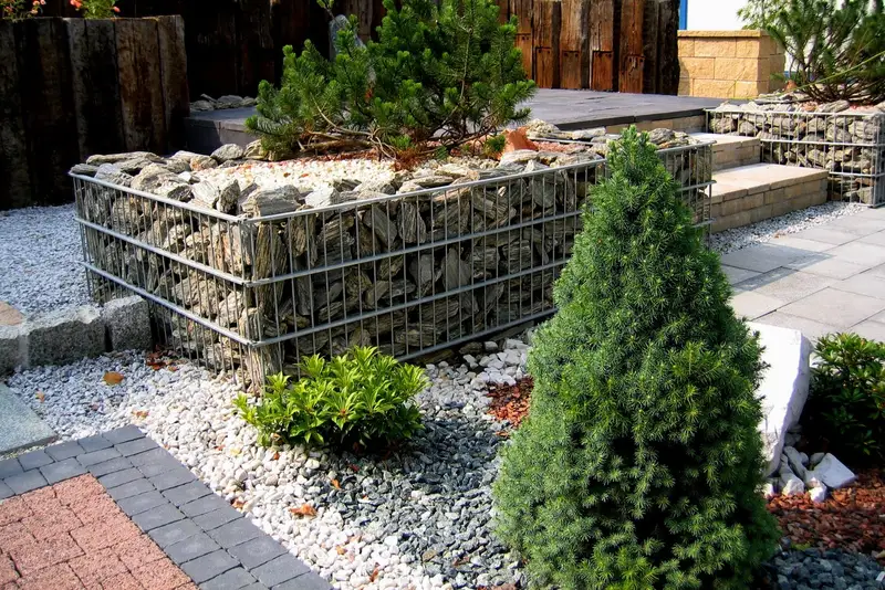 Gabion wypełniony kamieniem i rabata z iglakami