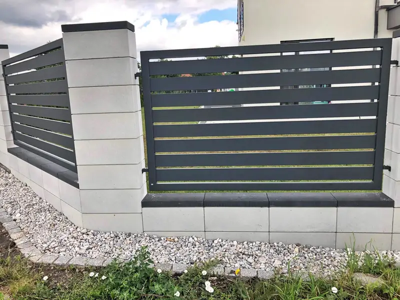Palisada pozioma między białymi słupkami z bloczków